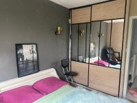 a bedroom with a bed with pink sheets and a mirror at Agréables chambres dans maison suspendue in Saint-Étienne