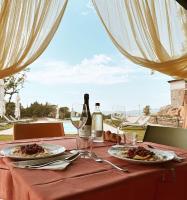 einen Tisch mit zwei Teller mit Speisen und Weingläsern in der Unterkunft Poggio Belvento in Suvereto