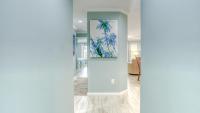 einen Flur mit einem Gemälde einer Palme in der Unterkunft Poolside Villas 106 - Updated beachfront condo on Holiday Isle in Destin in Destin