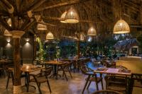 ein Restaurant mit Tischen, Stühlen und Kronleuchtern in der Unterkunft Alsus Boutique Hotel - Adults Only in Ammoudara