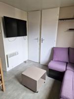 a living room with a purple couch and a tv at Bungalow de 3 chambres avec piscine partagee et terrasse a Vias a 1 km de la plage in Vias