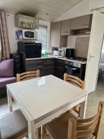 a kitchen with a white table and chairs at Bungalow de 3 chambres avec piscine partagee et terrasse a Vias a 1 km de la plage in Vias