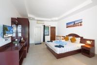 Un dormitorio con una cama, un escritorio y un televisor. en Grand View, en Patong Beach