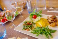 una mesa con platos de comida y copas de vino en SOWELL HOTELS Le Pas du Loup, en Isola 2000