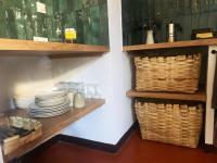 una cocina con estanterías de madera, platos y cestas en La Demeure du Pont Vieux, en Collobrières