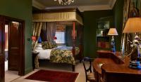 a bedroom with a canopy bed and green walls at The Rookery in London