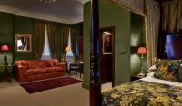 a bedroom with green walls and a bed and a chair at The Rookery in London