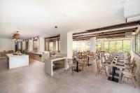 un restaurant avec des tables et des chaises dans une salle dans l'établissement Luxury Villa Muse Calliope, à Matala
