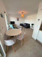 a living room with a table and chairs and a couch at Exceptionnelle Vue Mer Calvi - Piscine - T2 in Calvi