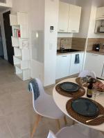 a kitchen with a table and chairs and a kitchen with white cabinets at Exceptionnelle Vue Mer Calvi - Piscine - T2 in Calvi