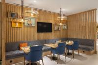 泰基尔达Hampton By Hilton Cerkezkoy的一家餐厅，里面有两张桌子、一张沙发和一台电视。