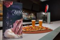 ein Buch neben einer Pizza mit einer Hand darauf in der Unterkunft Marriott's Crystal Shores in Marco Island