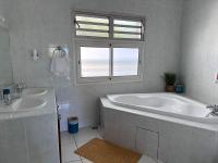 a bathroom with two sinks and a tub and a window at Hôtel Résidence Le Phoenix in Saint-Pierre