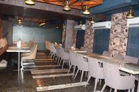 un restaurante con una fila de mesas y sillas en CRYTSAL RESIDENCY, en Ranchi