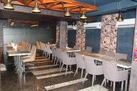 Un restaurante con mesas y sillas en una sala. en CRYTSAL RESIDENCY, en Ranchi