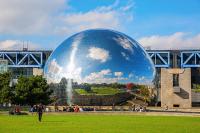 a person walking in front of a large ball in a field at Studio de charme in Pantin