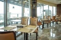 Un comedor con mesas y sillas y ventanas. en STwin Hotel, en Abha