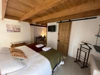 a bedroom with a large white bed and a television at LE CLOS DE FLO 17 in Saint-Rogatien