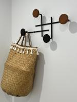 a rattan purse hanging on a wall with a sign at LE CLOS DE FLO 17 in Saint-Rogatien