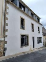 a white building with windows on a street at Beau Duplex Neuf Calme Lumineux 45m2 en plein COEUR de la station à 100m du port sur book ing &amp; rbnb in Bénodet