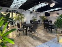 uma sala de jantar com mesas, cadeiras e plantas em Maria Aliyah Events and Resort em Santa Cruz