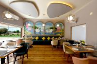 a restaurant with tables and chairs and windows at THE GANGA RESORT in Bikaner