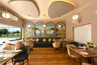 a restaurant with tables and chairs and windows at THE GANGA RESORT in Bikaner