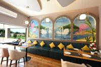 a restaurant with a green couch in a room with windows at THE GANGA RESORT in Bikaner