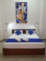 a bedroom with a bed with a painting on the wall at Everdew Kandy Rooms in Kandy