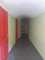 an empty hallway with a red door and green walls at Gîte Olivia in Saint-Florent-sur-Auzonnet