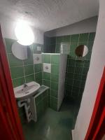 a bathroom with a sink and a green tiled wall at Gîte Olivia in Saint-Florent-sur-Auzonnet