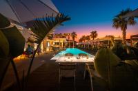 uma piscina com mesas e cadeiras ao lado de um resort em Insulae Resort em Cefalù