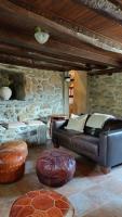 a living room with a leather couch and a stone wall at Maison en Cerdagne avec belle vue in Enveitg