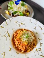 ein Teller Nudeln mit Käse und ein Teller Salat in der Unterkunft Mahogany Resort & Spa in El Nido
