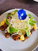 ein Teller Pasta mit einer blauen Blume darauf in der Unterkunft Mahogany Resort & Spa in El Nido