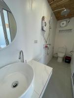 a bathroom with a sink and a mirror and a toilet at Nice Sea Resort in Srithanu
