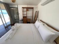 a bedroom with a bed with white sheets and pillows at Nice Sea Resort in Srithanu