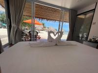 two white swans sitting on top of a bed at Nice Sea Resort in Srithanu