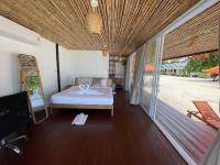 a bedroom with a bed on a wooden floor at Nice Sea Resort in Srithanu