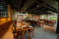 a dining room with wooden tables and chairs at ANANSA BOUTIQUE HOTEL by The Kannur Club in Kannur