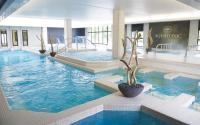 a large pool with blue water in a building at House with garden Disneyland Paris in Magny-le-Hongre