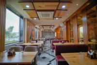 Un restaurante con mesas y sillas y un gran ventanal. en The Ekling Garh Hotel & Resort, en Udaipur