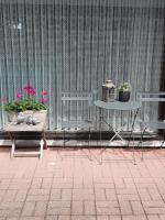 a patio with a table and two chairs and potted plants at Logies Lily in Oudenburg