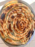 a large pie in a pan on a table at Guesthouse Kevin in Kukës