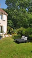 a black bench sitting in the grass next to a house at Chez Laurence &amp; RV in Vauréal