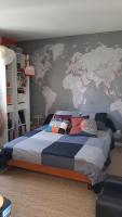 a bedroom with a large bed with a map on the wall at Chez Laurence &amp; RV in Vauréal