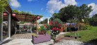 a garden with a pergola and a grill at MAISON &amp; PISCINE PRIVES,PLAGES OCEAN ET LAC A 10 kms in Linxe