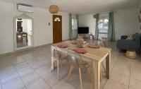 a kitchen and living room with a wooden table and chairs at Mas des catalanes dépendance privé climatisation, wifi 2MASCAT39 in Perpignan