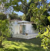 a white house with a patio with an umbrella at Mas des catalanes dépendance privé climatisation, wifi 2MASCAT39 in Perpignan