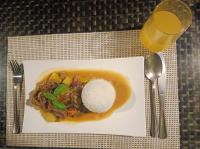 un plato de comida con arroz y un vaso de zumo de naranja en Palawan SandCastles, en Minuit